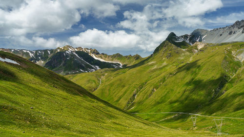 Scenic view of green landscape and mountains against sky