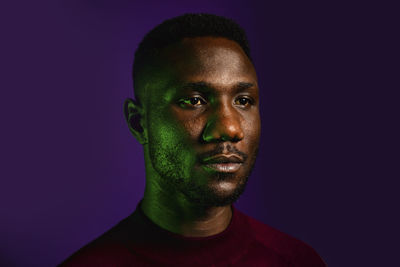 Portrait of young man against black background