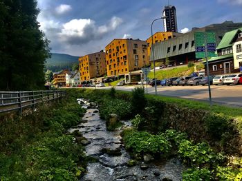 Street by buildings against sky in city