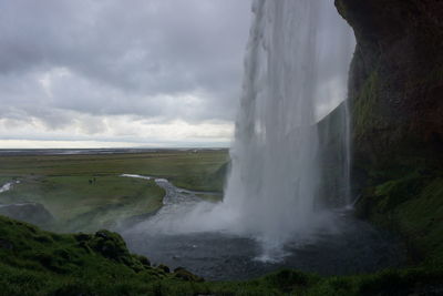 Scenic view of waterfall against sky