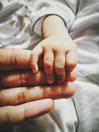 Close-up of baby hand on bed