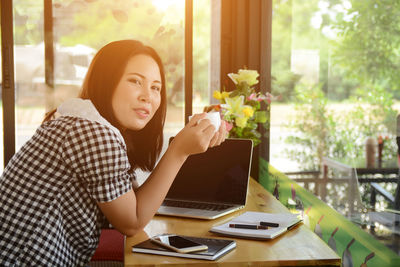 Young woman using phone on table