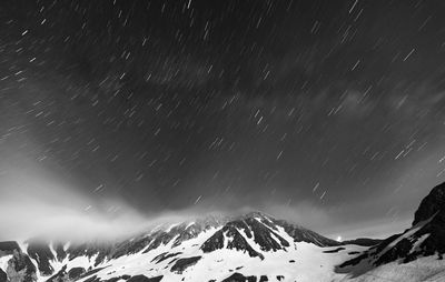 Scenic view of snowcapped mountains against sky at night