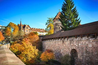 Buildings by autumn trees in city