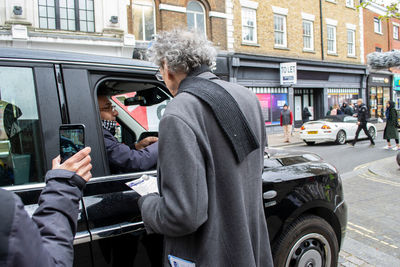 Man using mobile phone on street in city