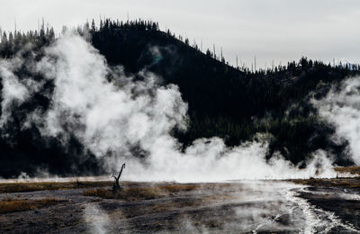 Steam on landscape against silhouette mountain range