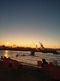 Pier at harbor against sky during sunset