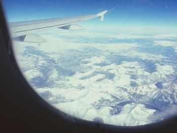 Cropped image of airplane wing over landscape