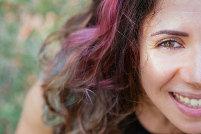 Close-up portrait of smiling woman with dyed hair