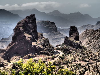 Scenic view of cliff by sea against sky