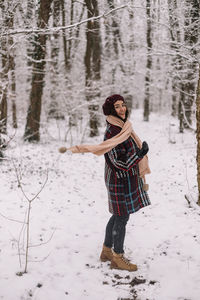 Full length of woman standing on snow covered field