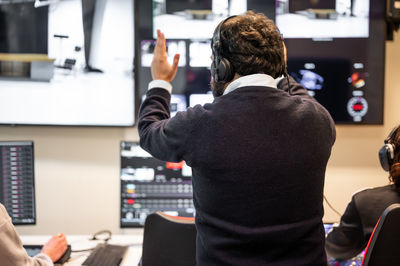 Rear view of man looking through window