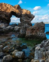 Rocks on sea shore against sky