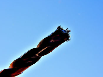 Low angle view of red flying against clear blue sky