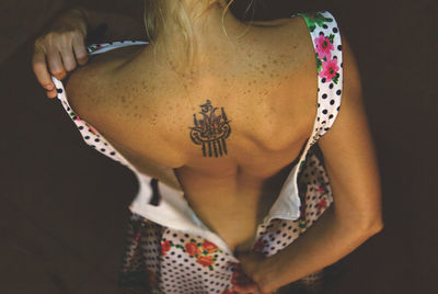 Rear view of woman unzipping dress