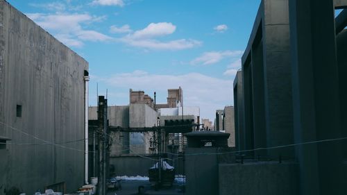 Buildings in city against cloudy sky
