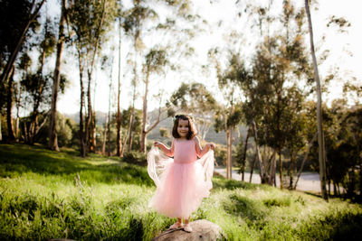 Young girl in tutu and flower crown posing in field