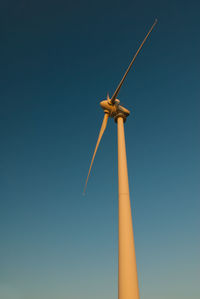 Low angle view of windmill against clear blue sky