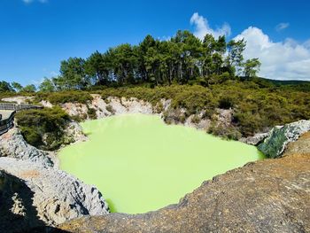 Scenic view of green lake against sky