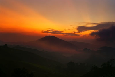 Scenic view of silhouette mountains against romantic sky at sunset