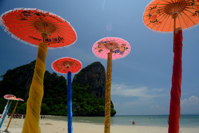 Low angle view of beach umbrellas at sea shore against sky