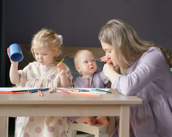 Cute girl and son sitting at home