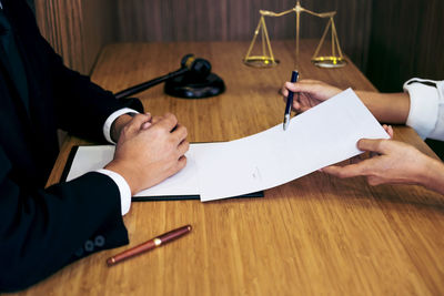 Cropped image of lawyers doing paperwork in office