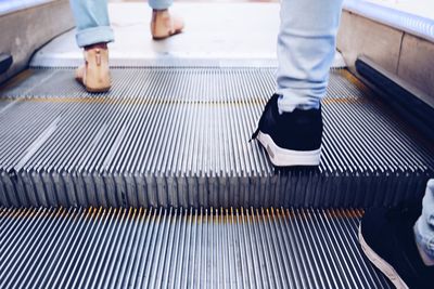 Low section of people on escalator