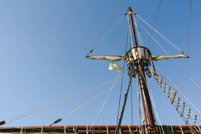 Low angle view of sailboat against clear blue sky