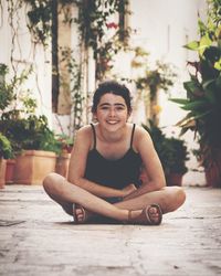 Portrait of smiling young woman sitting outdoors