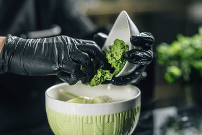 Chef's hand preparing pesto genovese in vegetarian restaurant