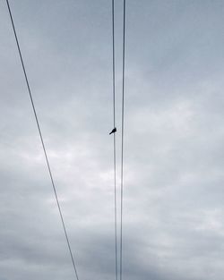 Low angle view of power lines against cloudy sky