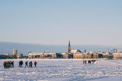 People in town square during winter against sky