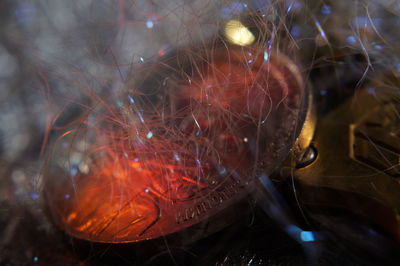 Close-up of burning candles on glass