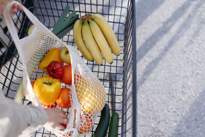 Woman packing organic fruits and vegetables to the eco bag. zero waste lifestyle concept