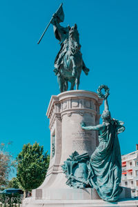 Low angle view of statue against blue sky