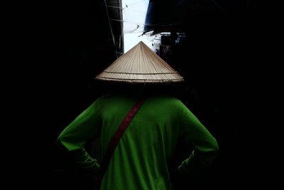 Rear view of man wearing asian style conical hat