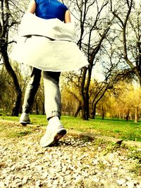 Low section of woman standing on field