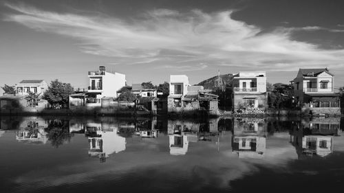 Reflection of buildings in lake against sky