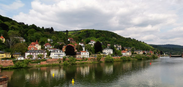 Scenic view of town by mountains against sky