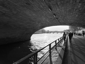 Rear view of man walking on bridge