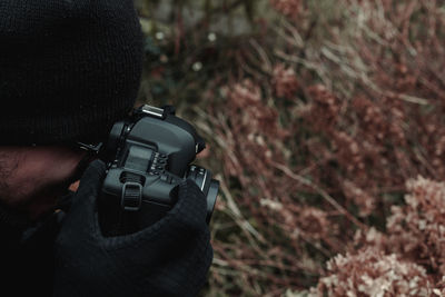 Close-up of man photographing plants through camera