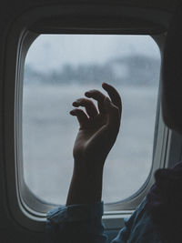Low angle view of man sitting in airplane window