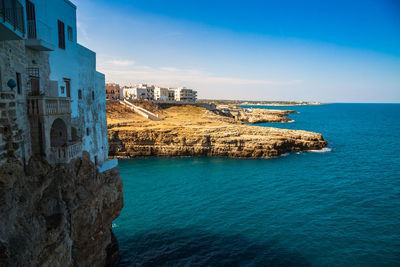 Scenic view of sea by buildings against sky