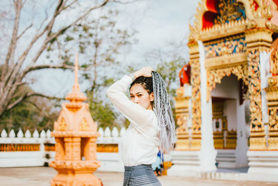 Woman standing outside temple against building