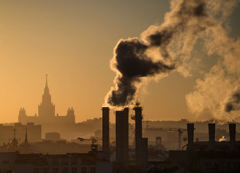 Silhouette of city against sky during sunset