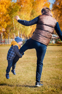 Dad and son play in nature. the child's emotions and delight. warm sunny autumn day in the park. 