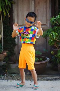 Full length of boy standing with arms raised