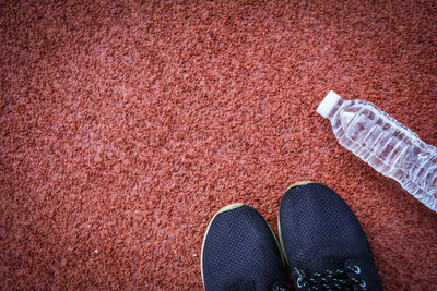 High angle view of shoes and water bottle on running track