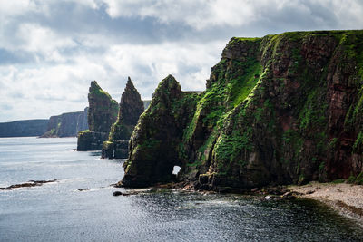 Panoramic view of rocks and sea against sky